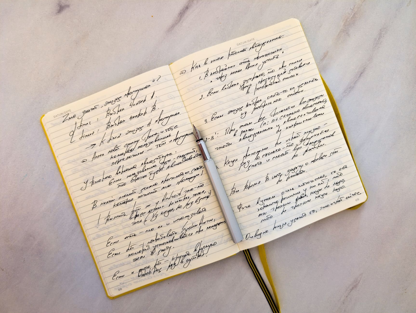Open notebook with cursive handwritten notes on a marble surface